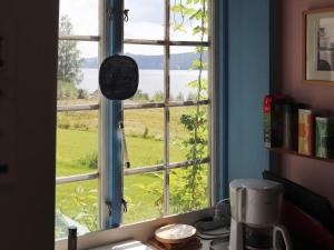 a kitchen window with a view of a green field at 6 person holiday home in STRA NTERVIK in Östra Ämtervik