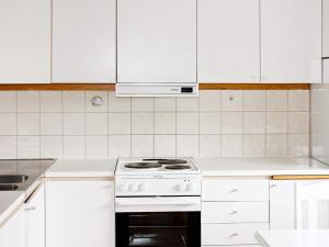 Biała kuchnia z kuchenką i białymi szafkami w obiekcie Apartment TÄLLBERG w mieście Tällberg