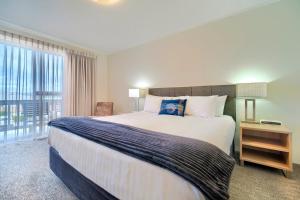 a bedroom with a large bed and a large window at Albany Motel & Apartments in Albany