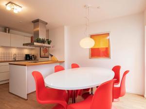 une cuisine avec une table blanche et des chaises rouges dans l'établissement 6 person holiday home in Skagen, à Skagen
