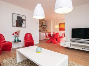 - un salon avec des chaises rouges et une télévision dans l'établissement 6 person holiday home in Skagen, à Skagen