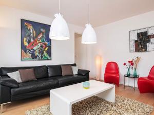 - un salon avec un canapé noir et des fauteuils rouges dans l'établissement 6 person holiday home in Skagen, à Skagen