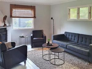 ein Wohnzimmer mit einem Sofa und 2 Stühlen in der Unterkunft 4 person holiday home in VEBER D in Veberöd