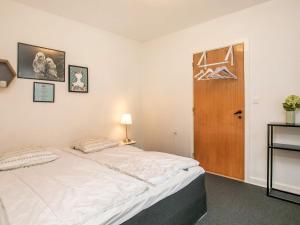 een slaapkamer met een bed en een houten deur bij 16 person holiday home in Rudk bing in Rudkøbing