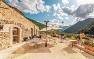 un patio con mesas, sillas y una sombrilla en Firminia, en Scheggino