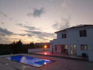 a villa with a swimming pool in front of a house at Kiti Village Villa Larnaca, salt-water pool, 5 bedrooms in Kiti