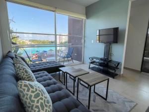 Una sala de estar con un sofá y un televisor de pantalla plana. en Dreams Lagoon by Andiani Travel, en Cancún