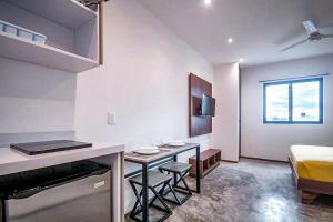 a room with a bed and a living room with a fireplace at dewl estudios : El Mexicano in Playa del Carmen