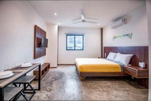 a bedroom with a bed and a desk and a television at dewl estudios : El Mexicano in Playa del Carmen +37 photos