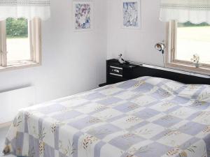1 dormitorio con 1 cama y 2 ventanas en 4 person holiday home in HEN N, en Henån