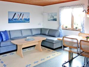 sala de estar con sofá azul y mesa en 4 person holiday home in HEN N, en Henån