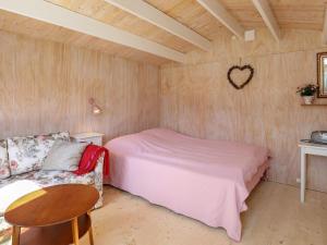 a bedroom with a bed and a chair and a table at 6 person holiday home in Stege in Stege