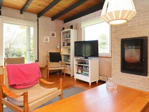 a living room with a tv and a couch and a table at 6 person holiday home in Stege in Stege