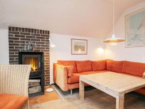 a living room with a couch and a fireplace at 6 person holiday home in Pandrup in Rødhus