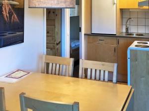 a kitchen with a wooden table and a table and chairs at Holiday home SÄLEN XXVII in Stöten