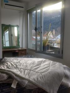 1 dormitorio con cama y ventana grande en SMA AltoRoca7, en San Martín de los Andes