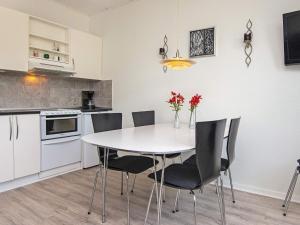een keuken met een witte tafel en stoelen in een kamer bij 4 person holiday home in R m in Sønderby