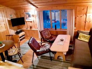 a living room with a table and chairs in a cabin at 5 person holiday home in Straumsbukta in Bakke