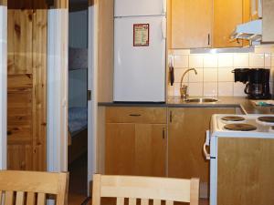 uma pequena cozinha com um frigorífico branco e uma mesa em 4 person holiday home in S LEN em Stöten
