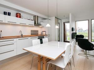 een keuken en eetkamer met een witte tafel en stoelen bij Apartment Bogense IV in Bogense