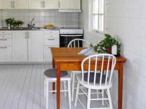 フンボストランドにある7 person holiday home in HUNNEBOSTRANDのキッチン(木製テーブル、白い椅子付)