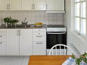 フンボストランドにある7 person holiday home in HUNNEBOSTRANDの白いキャビネットとシンク付きのキッチン
