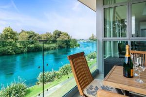uma sala de jantar com vista para um rio em Two Views Taupo Apartment em Taupo