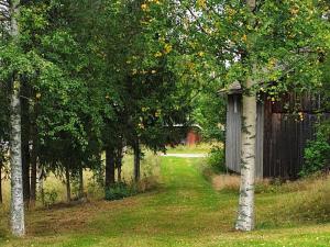 a garden with a fence and trees and a path at 4 person holiday home in J RVS in Järvsö