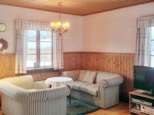 uma sala de estar com duas cadeiras e um sofá e uma televisão em Holiday home NORDINGRÅ em Nordingrå
