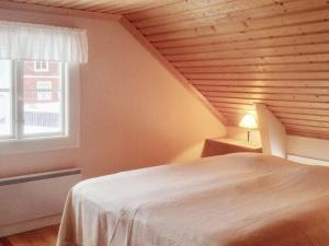 a bedroom with a white bed and a window at Holiday home NORDINGRÅ in Nordingrå