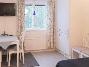 ein Wohnzimmer mit einem Tisch und einem Fenster in der Unterkunft 4 person holiday home in LJUSDAL in Ljusdal