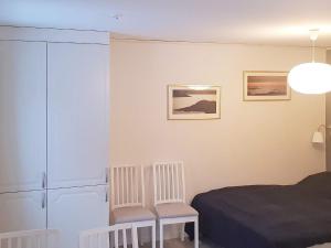 a bedroom with a bed and two chairs at 4 person holiday home in LJUSDAL in Ljusdal