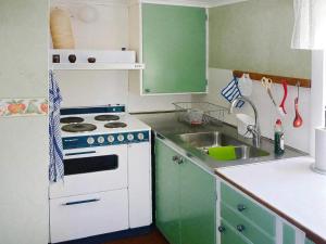 een kleine keuken met een fornuis en een wastafel bij 5 person holiday home in LAMMHULT in Lammhult