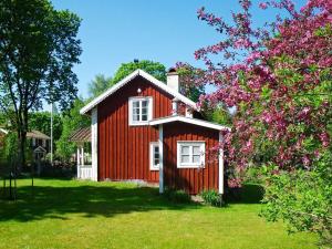 een rood huis met witte ramen en een boom bij 5 person holiday home in LAMMHULT in Lammhult