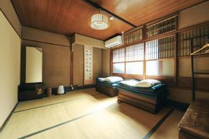Cette chambre comprend 2 lits et une fenêtre. dans l'établissement Gojo Guest House, à Kyoto