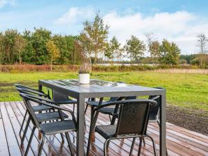 a table and chairs on a deck with a field at 8 person holiday home in Ansager in Ansager