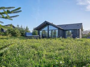 a house in the middle of a field of grass at Holiday home Aakirkeby XXI in Vester Sømarken