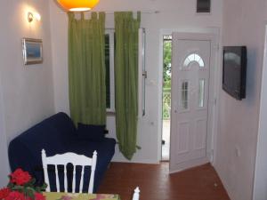 sala de estar con sofá azul y cortinas verdes en Apartments Zora, en Pirovac