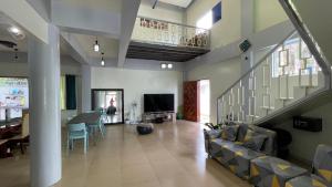 sala de estar con escalera, sofá y TV en Charming Apartelle with Swimming Pool -Exclusive, en Davao City