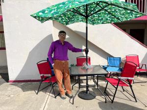 a man standing next to a table with an umbrella at MOTEL 9 in Elyria