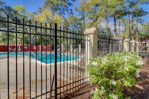 an iron fence with a swimming pool behind it at #114 Colorful Charming Condo 2BDR/2 Parking in Hilton Head Island