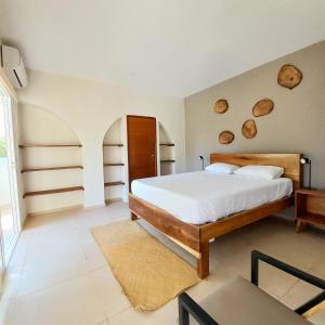 a bedroom with a bed with white sheets and logs on the wall at Casaola Mizata in Santa María Mizata