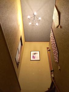 a hallway with a staircase with a chandelier at Yumeji Guest House in Osaka