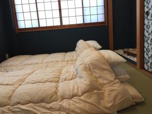 a large white bed in a room with a window at Yumeji Guest House in Osaka