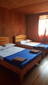 een slaapkamer met 2 bedden en een raam bij 7th Heaven Lodge and Cafe in Banaue