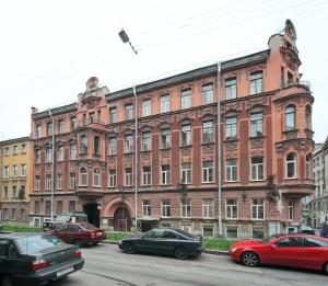 a large brick building with cars parked in front of it at Rinaldi Olympia in Saint Petersburg