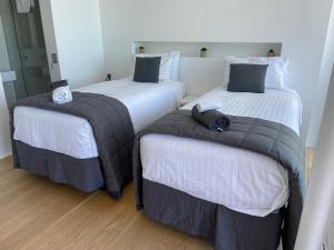 duas camas sentadas uma ao lado da outra num quarto em LUXURIOUS WATERFRONT Home em Nelson