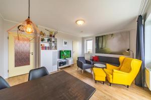 ein Wohnzimmer mit einem Tisch und gelben Stühlen in der Unterkunft Hus Inselkieker Hus Inselkieker 425 in Schillig