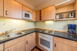 eine Küche mit Holzschränken und einer Spüle in der Unterkunft Hus Inselkieker Hus Inselkieker 425 in Schillig + 3 Fotos