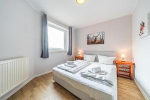 ein Schlafzimmer mit einem weißen Bett und einem Fenster in der Unterkunft Hus Inselkieker Hus Inselkieker 425 in Schillig